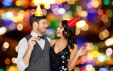 Image showing happy couple with party blowers having fun