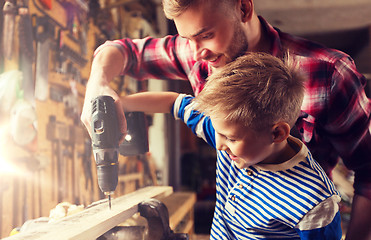 Image showing father and son with drill working at workshop