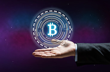 Image showing close up of businessman hand with bitcoin hologram