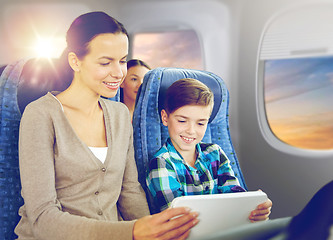 Image showing happy family with tablet pc sitting in plane