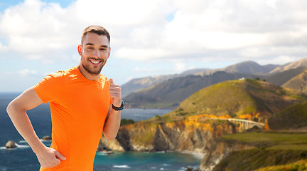 Image showing smiling young man running at summer seaside