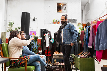 Image showing friends choosing clothes at vintage clothing store