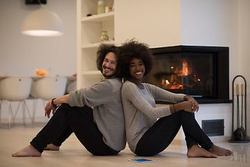 Image showing multiethnic couple with tablet computer on the floor