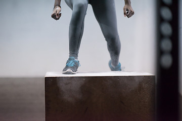 Image showing black woman is performing box jumps at gym