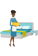 Image showing African housekeeping maid with stack of linen.