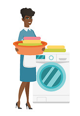 Image showing Housewife using washing machine at laundry.