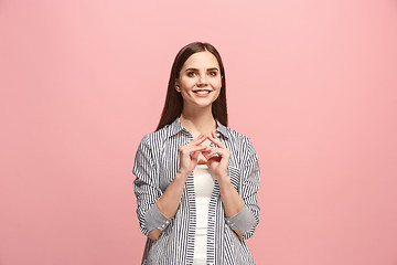 Image showing The happy business woman standing and smiling against pink background.