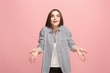 Image showing Beautiful female half-length portrait isolated on pink studio backgroud. The young emotional surprised woman