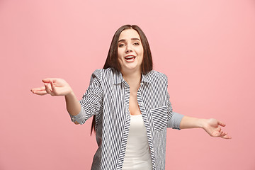 Image showing Beautiful female half-length portrait isolated on pink studio backgroud. The young emotional surprised woman