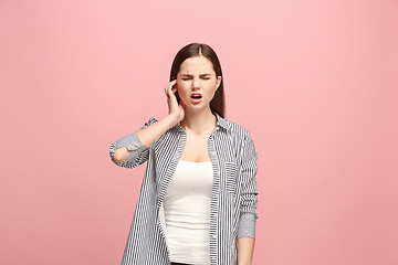 Image showing The Ear ache. The sad woman with headache or pain on a pink studio background.