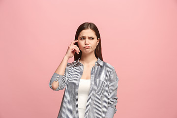 Image showing Let me think. Doubtful pensive woman with thoughtful expression making choice against pink background