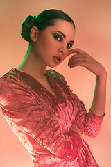 Image showing High Fashion model woman in colorful bright lights posing in studio,