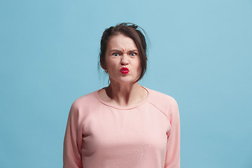 Image showing Portrait of an angry woman looking at camera isolated on a blue background