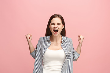 Image showing The young emotional angry woman screaming on pink studio background