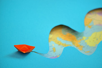Image showing Paper boat making waves on a blue background 