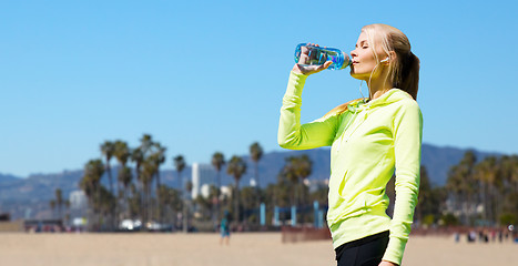 Image showing woman drinking water after doing sports outdoors