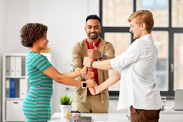 Image showing happy creative team making high five at office