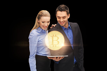 Image showing businesspeople with tablet pc and bitcoin hologram