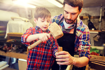 Image showing father and son with chisel working at workshop