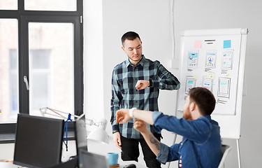 Image showing man showing smart watch to creative team at office