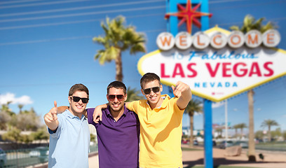 Image showing group of male friends hugging over las vegas sign