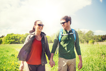 Image showing happy couple with backpacks hiking outdoors