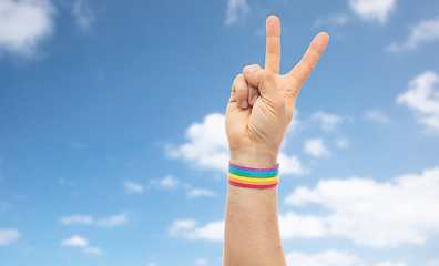 Image showing hand with gay pride rainbow wristband make peace