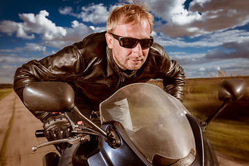 Image showing Biker racing on the road