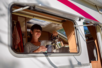 Image showing Woman cooking in camper, motorhome interior