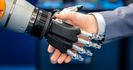 Image showing Hand of a businessman shaking hands with a droid robot. The conc