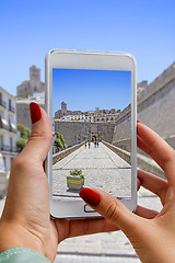 Image showing Young girl with mobile phone photographs Entry to the Ibiza old 