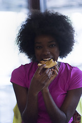 Image showing woman with afro hairstyle eating tasty pizza slice