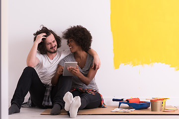 Image showing young multiethnic couple relaxing after painting