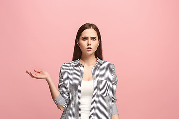 Image showing Let me think. Doubtful pensive woman with thoughtful expression making choice against pink background