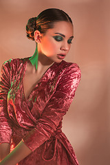 Image showing High Fashion model woman in colorful bright lights posing in studio,