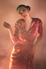 Image showing High Fashion model woman in colorful bright lights posing in studio,