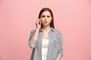 Image showing Let me think. Doubtful pensive woman with thoughtful expression making choice against pink background