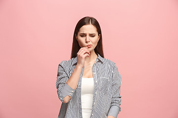 Image showing Let me think. Doubtful pensive woman with thoughtful expression making choice against pink background