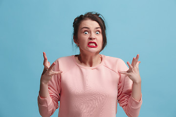 Image showing Portrait of an angry woman looking at camera isolated on a blue background