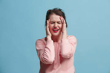 Image showing Woman having headache. Isolated over blue background.