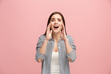 Image showing The young emotional angry woman screaming on pink studio background