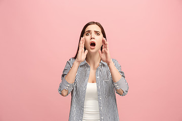 Image showing The young emotional angry woman screaming on pink studio background