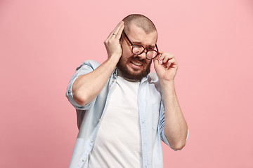 Image showing The Ear ache. The sad man with headache or pain on a pink studio background.