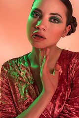 Image showing High Fashion model woman in colorful bright lights posing in studio,