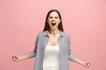 Image showing The young emotional angry woman screaming on pink studio background