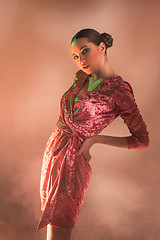 Image showing High Fashion model woman in colorful bright lights posing in studio,