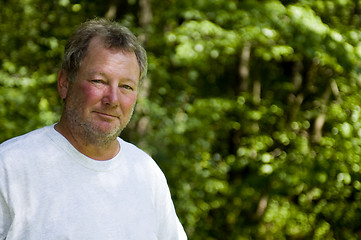 Image showing happy middle age man wooded background