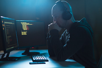 Image showing hacker with coding on laptop computer in dark room