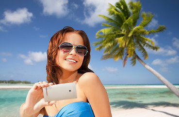 Image showing woman taking selfie by smartphone on beach