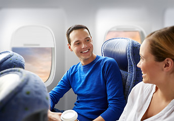 Image showing happy passengers with coffee talking in plane